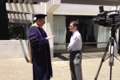 Doing a quick television interview after graduation in June.