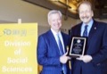 Chancellor Blumenthal presents Steve Bruce with the Social Sciences Distinguished Alumni Award in April.